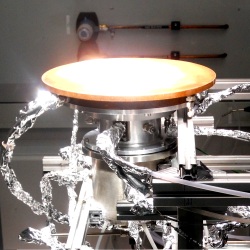 The reaction chamber where sunlight becomes chemical energy. This picture shows the reaction chamber of the new solar collector illuminated by light coming from a solar simulator. A quartz window at the top allows both infrared and ultraviolet radiation to enter the chamber where the cerium oxide is deposited.