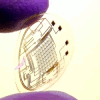 A contact lens with integrated circuitry. A researcher of the University of Washington holds a contact lens which embeds LEDs and other electrical components and which is manufactured using their newly developed self-assembly technique.